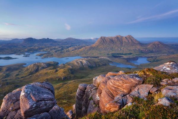 A view from the top of a mountain, across hills and mountains