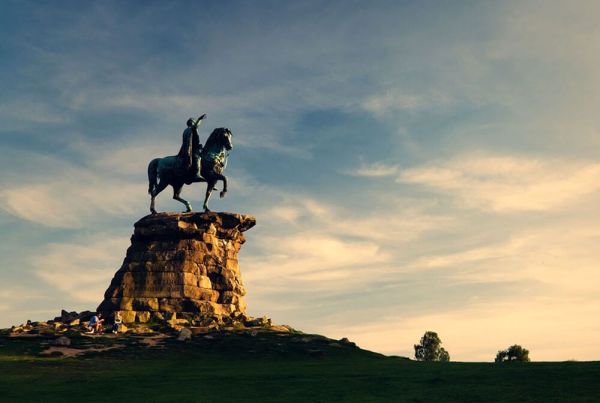 A statue of a man upon horseback, standing upon a stack of rocks