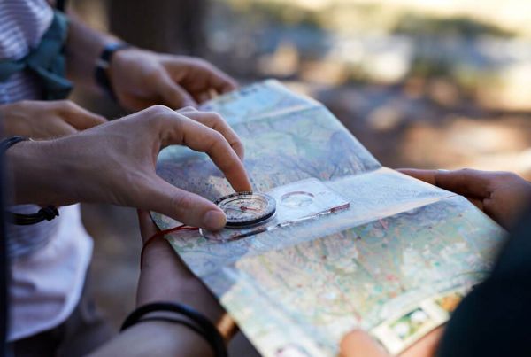 People using compass to read map