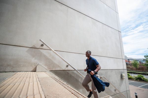 A man climbing the steps of a large building