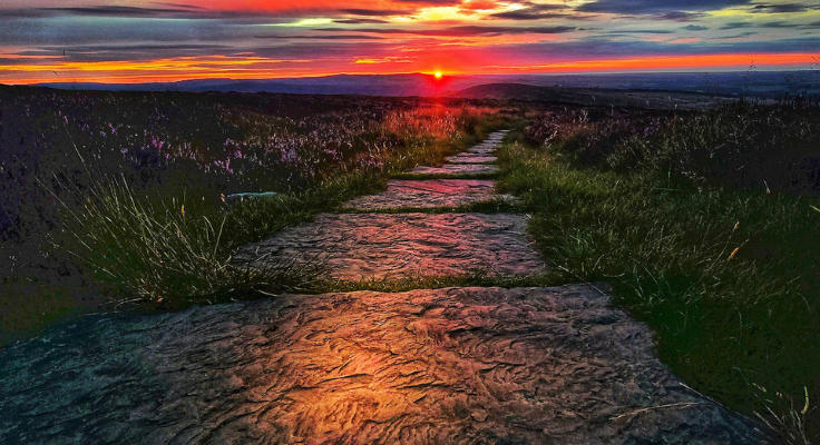 The sun sets on a flagstone path atop Simonside Ridge